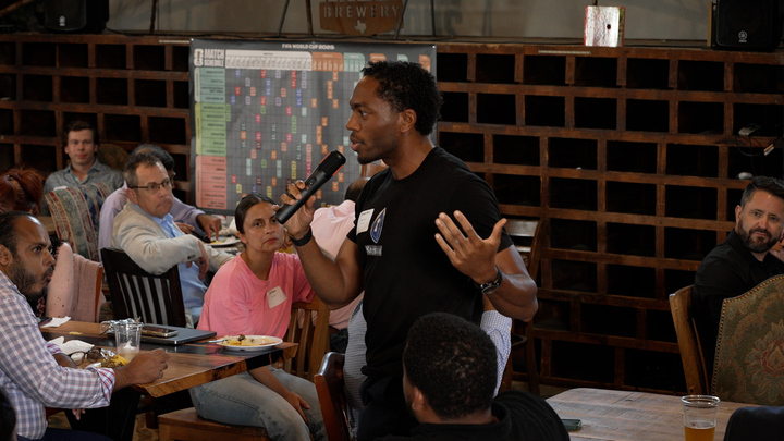 Builder addressing the room with a microphone